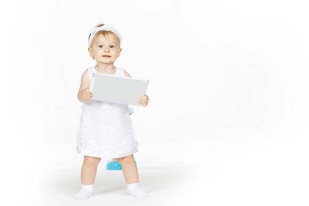 little girl all in white with a tabletの写真素材