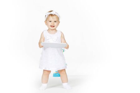 little girl all in white with a tabletの写真素材