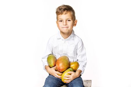 handsome boy in a white shirt with mangoの写真素材