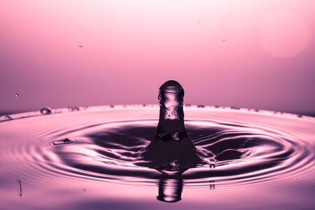 drop of water falling down in the waterの写真素材