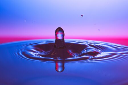 drop of water falling down in the waterの写真素材