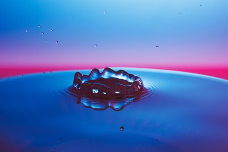 drop of water falling down in the waterの写真素材