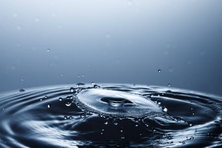 drop of water falling down in the waterの写真素材