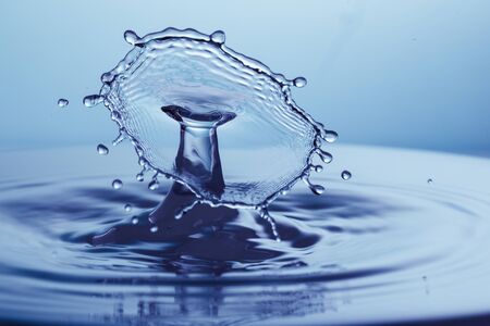 drop of water falling down in the waterの写真素材