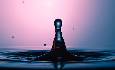 drop of water falling down in the waterの写真素材