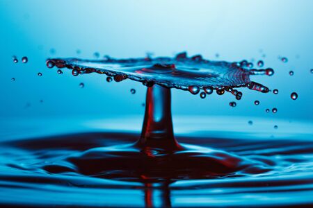 drop of water falling down in the waterの写真素材