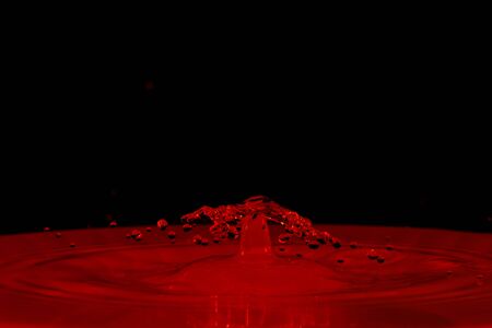 drop of water falling down in the waterの写真素材
