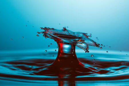 drop of water falling down in the waterの写真素材