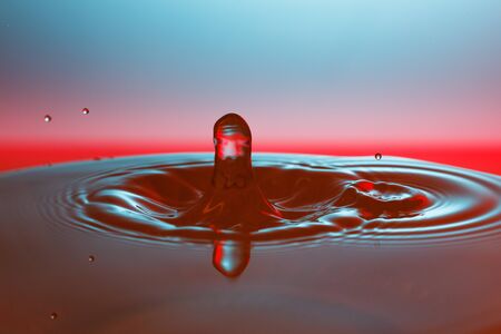 drop of water falling down in the waterの写真素材