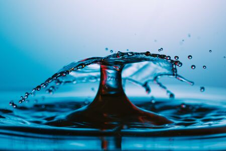 drop of water falling down in the waterの写真素材