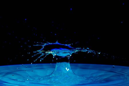 drop of water falling down in the waterの写真素材