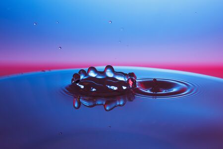 drop of water falling down in the waterの写真素材