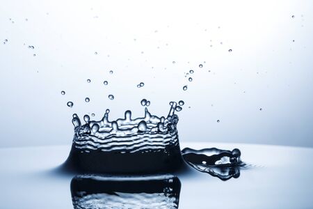 drop of water falling down in the waterの写真素材