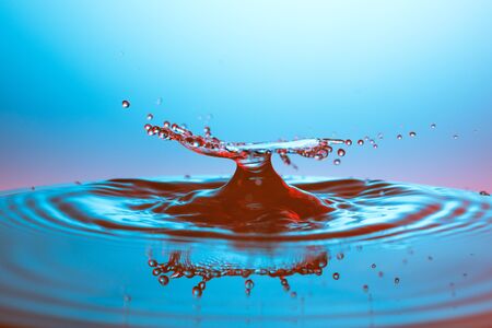 drop of water falling down in the waterの写真素材