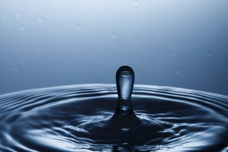 drop of water falling down in the waterの写真素材