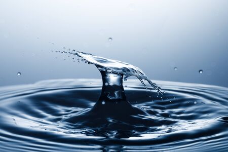 drop of water falling down in the waterの写真素材