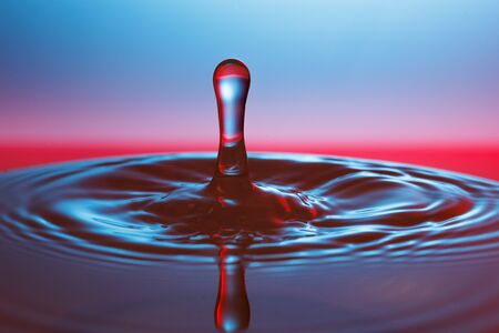 drop of water falling down in the waterの写真素材