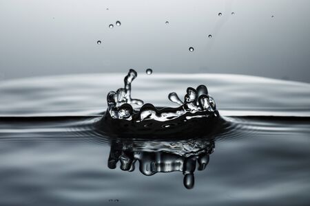 drop of water falling down in the waterの写真素材