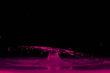 drop of water falling down in the waterの写真素材