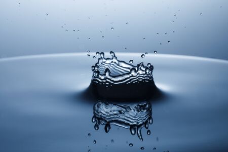 drop of water falling down in the waterの写真素材