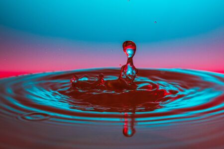 drop of water falling down in the waterの写真素材
