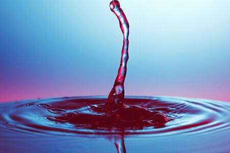 drop of water falling down in the waterの写真素材