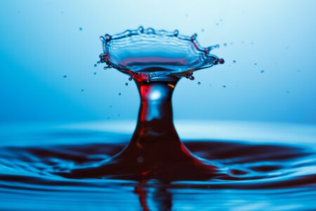 drop of water falling down in the waterの写真素材