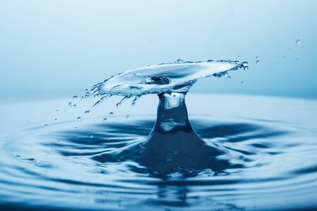 drop of water falling down in the waterの写真素材