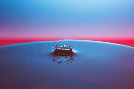 drop of water falling down in the waterの写真素材