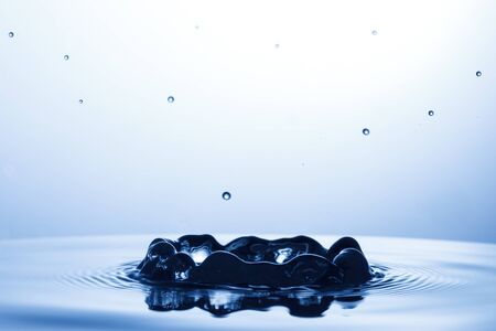 drop of water falling down in the waterの写真素材