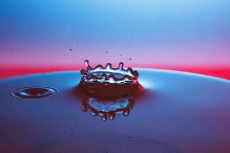 drop of water falling down in the waterの写真素材