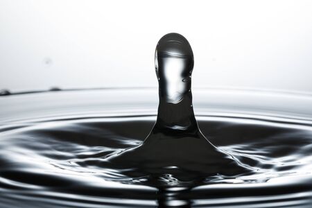 drop of water falling down in the waterの写真素材