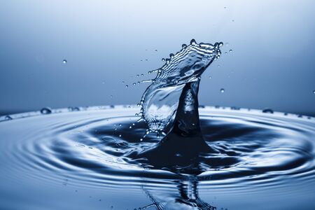 drop of water falling down in the waterの写真素材
