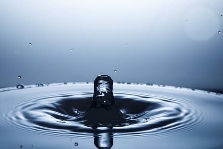 drop of water falling down in the waterの写真素材
