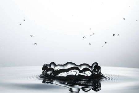 drop of water falling down in the waterの写真素材