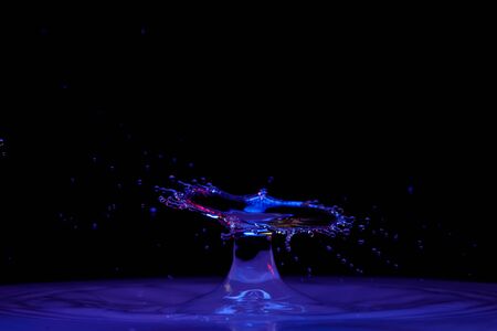 drop of water falling down in the waterの写真素材