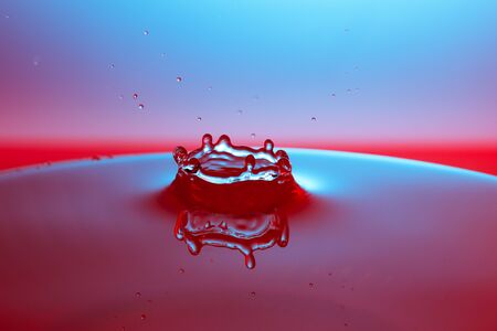 drop of water falling down in the waterの写真素材