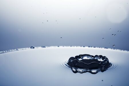 drop of water falling down in the waterの写真素材