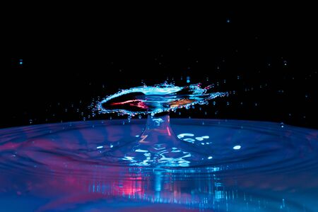 drop of water falling down in the waterの写真素材