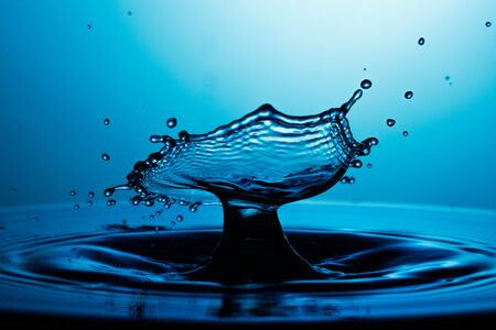 drop of water falling down in the waterの写真素材