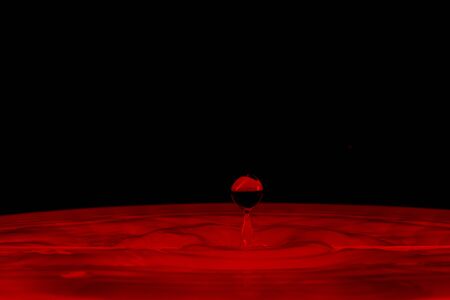 drop of water falling down in the waterの写真素材