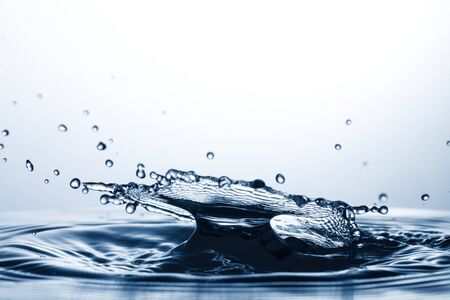 drop of water falling down in the waterの写真素材