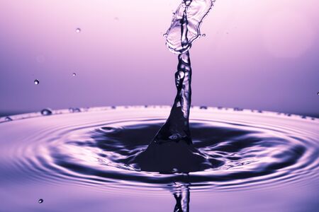 drop of water falling down in the waterの写真素材