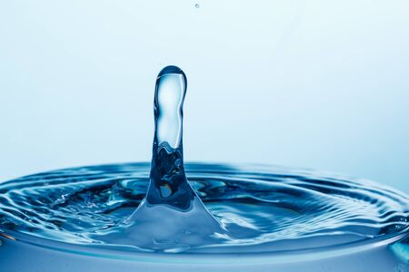 drop of water falling down in the waterの写真素材