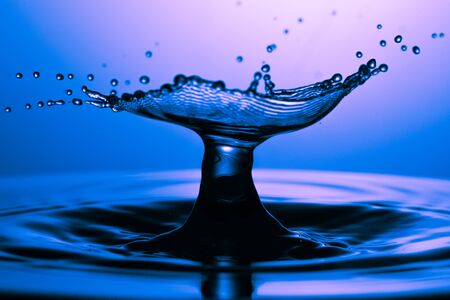 drop of water falling down in the waterの写真素材