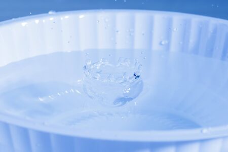 drop of water falling down in the waterの写真素材