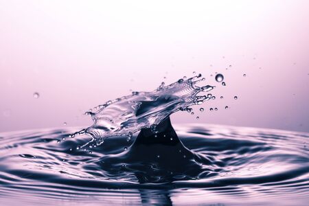 drop of water falling down in the waterの写真素材