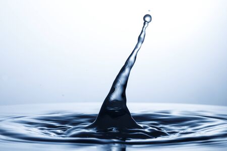 drop of water falling down in the waterの写真素材