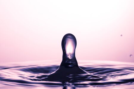 drop of water falling down in the waterの写真素材