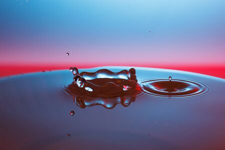 drop of water falling down in the waterの写真素材